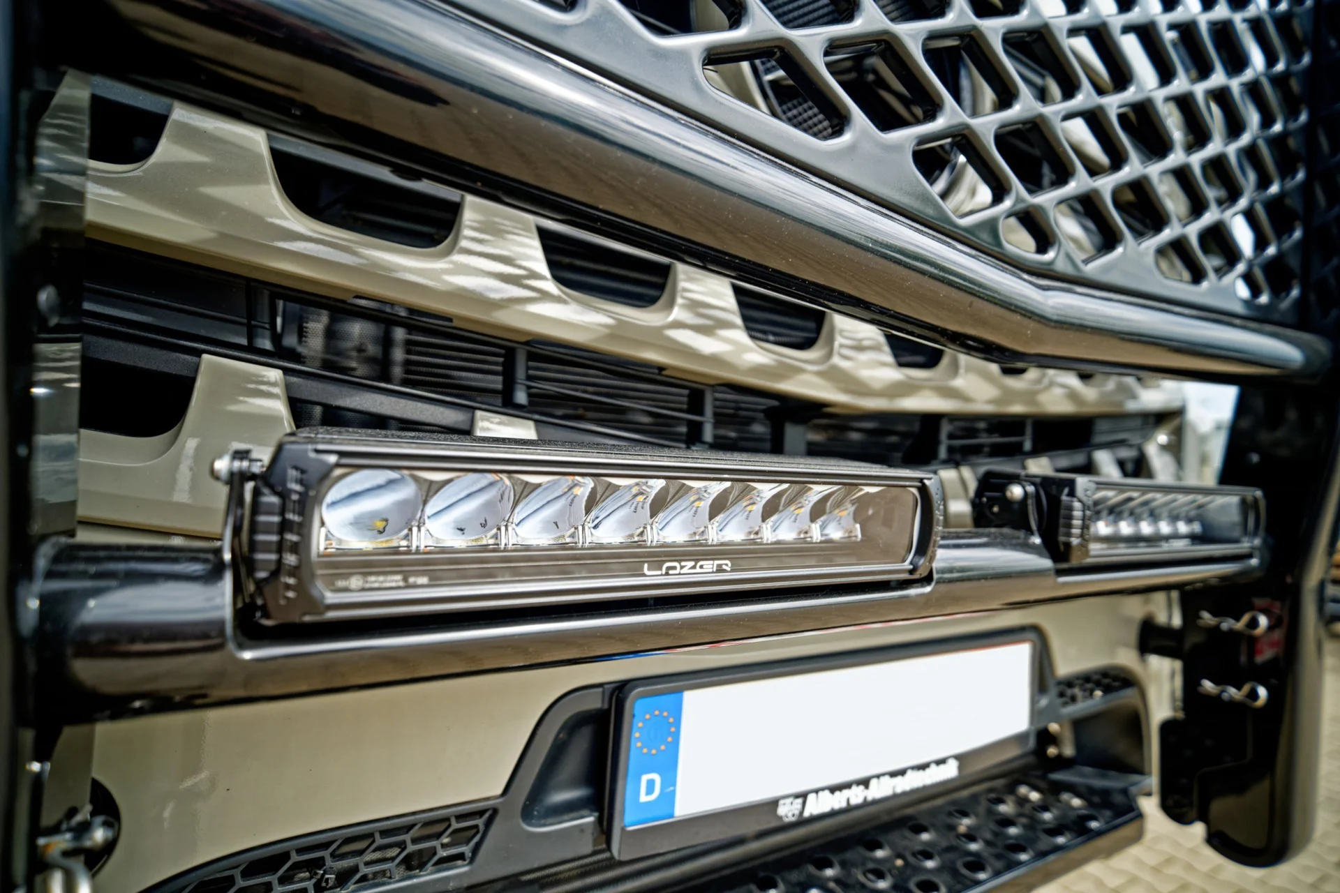 Detailaufnahme der Front eines Fahrzeugs mit integriertem LED-Lightbar und sichtbarem deutschen Nummernschild ohne erkennbare Nummer.